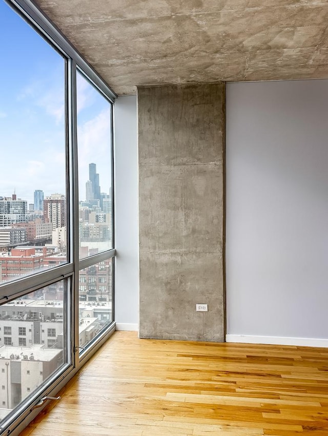 1845 S Michigan Ave Unit 1602, Chicago, IL 60616 - unfurnished room with a city view, wood finished floors, floor to ceiling windows, and baseboards
