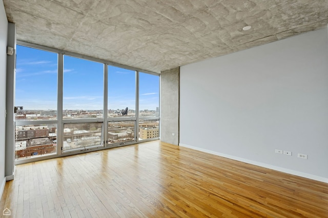 1845 S Michigan Ave Unit 1602, Chicago, IL 60616 - unfurnished room featuring expansive windows, hardwood / wood-style flooring, a view of city, and baseboards