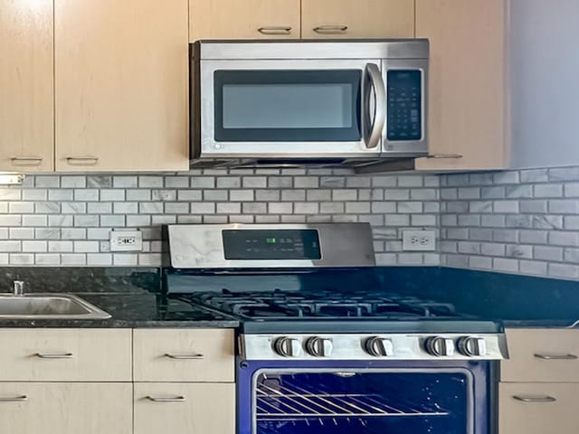 1845 S Michigan Ave Unit 1602, Chicago, IL 60616 - kitchen featuring appliances with stainless steel finishes, tasteful backsplash, dark stone counters, and a sink