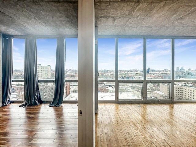 1845 S Michigan Ave Unit 1602, Chicago, IL 60616 - spare room with a wall of windows, a view of city, plenty of natural light, and wood-type flooring