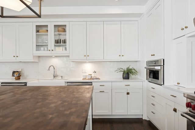 1307 W Wrightwood Ave Unit 201, Chicago, IL 60614 - kitchen featuring white cabinetry, glass insert cabinets, dark wood-style floors, appliances with stainless steel finishes, and decorative backsplash