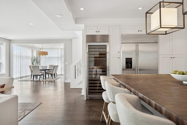 1307 W Wrightwood Ave Unit 201, Chicago, IL 60614 - kitchen featuring stainless steel built in refrigerator, beverage cooler, dark wood-style floors, white cabinets, and pendant lighting