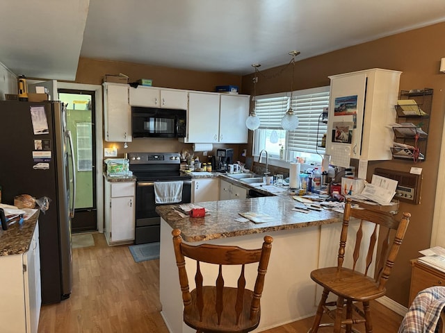 1645 Meadowview Ln, Wilmington, IL 60481 - kitchen with electric range, black microwave, a sink, a peninsula, and freestanding refrigerator