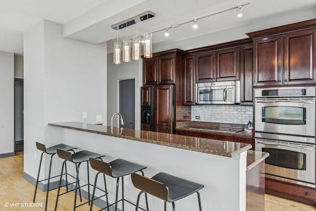 1235 S Prairie Ave Unit 3605, Chicago, IL 60605 - kitchen with appliances with stainless steel finishes, a breakfast bar area, dark stone countertops, and backsplash