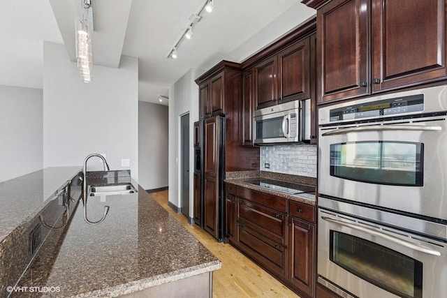 1235 S Prairie Ave Unit 3605, Chicago, IL 60605 - kitchen featuring a sink, stainless steel appliances, dark stone counters, light wood finished floors, and tasteful backsplash