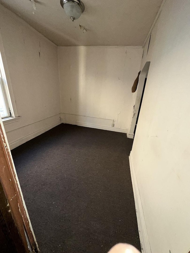 7425 S Harvard Ave, Chicago, IL 60621 - empty room featuring dark colored carpet and baseboards