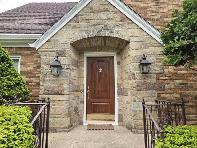 210 S Ridge St, Shannon, IL 61078 - doorway to property featuring stone siding, a shingled roof, and brick siding