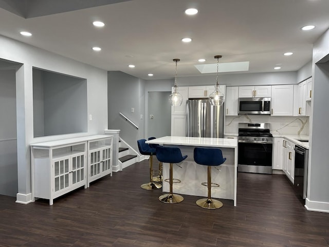 7729 W 157th Pl, Orland Park, IL 60462 - kitchen with appliances with stainless steel finishes, tasteful backsplash, a kitchen breakfast bar, dark wood-style flooring, and recessed lighting