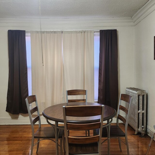 7601 S Morgan St, Chicago, IL 60620 - dining room with wood finished floors, a textured ceiling, crown molding, and radiator