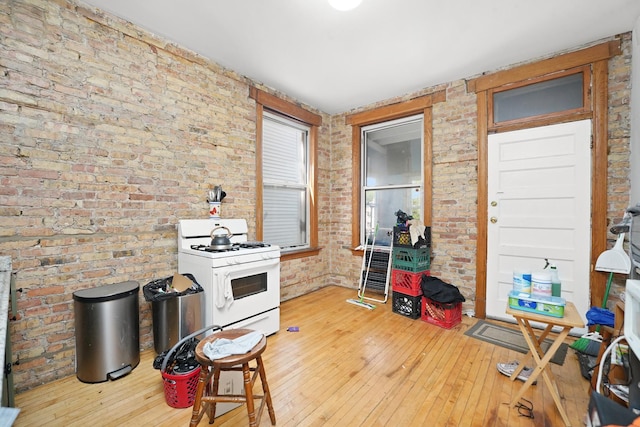 1518 N Kedzie Ave, Chicago, IL 60651 - kitchen with white gas stove, wood-type flooring, and brick wall
