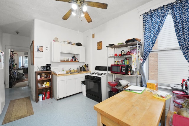 1518 N Kedzie Ave, Chicago, IL 60651 - kitchen with gas range, open shelves, a sink, ceiling fan, and white cabinetry