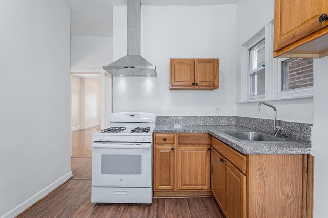 2439 S Millard Ave, Chicago, IL 60623 - kitchen featuring wall chimney range hood, white range with gas cooktop, a sink, dark wood finished floors, and brown cabinets