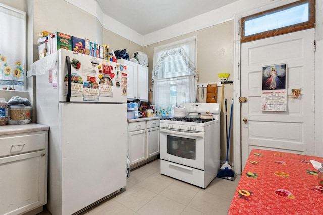 2439 S Millard Ave, Chicago, IL 60623 - kitchen featuring white appliances, light tile patterned flooring, light countertops, and white cabinets