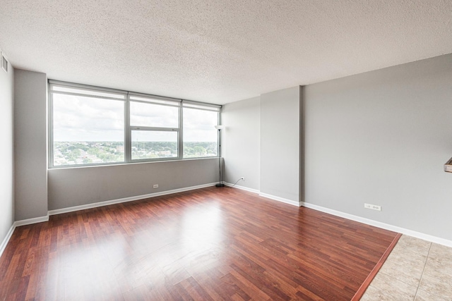 7234 W N Ave Unit 1608, Elmwood Park, IL 60707 - unfurnished room featuring plenty of natural light, a textured ceiling, wood finished floors, and baseboards
