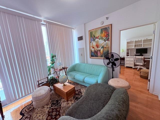 living area with wood finished floors, a desk, and plenty of natural light