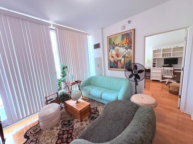 living area featuring wood finished floors, a desk, and plenty of natural light