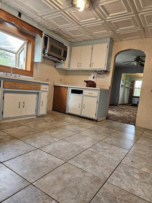 3500 Butler Ave, Steger, IL 60475 - kitchen with stainless steel microwave, a ceiling fan, arched walkways, an ornate ceiling, and light countertops
