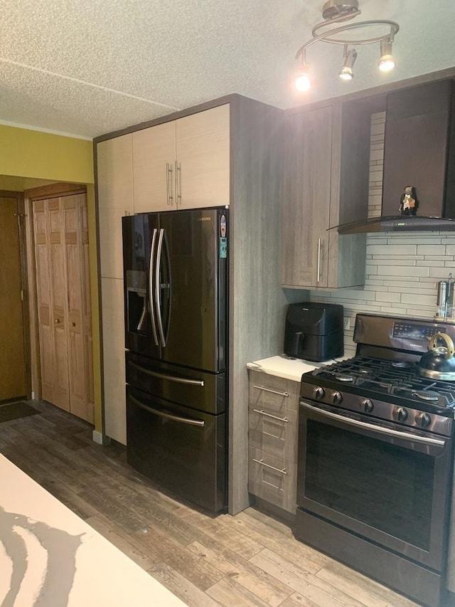 6430 W Belle Plaine Ave Unit 202, Chicago, IL 60634 - kitchen featuring stainless steel range with gas stovetop, fridge with ice dispenser, wall chimney exhaust hood, light wood-type flooring, and a textured ceiling