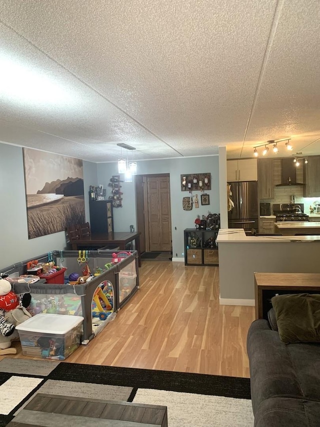 6430 W Belle Plaine Ave Unit 202, Chicago, IL 60634 - living room with a textured ceiling, light wood-style floors, track lighting, and baseboards