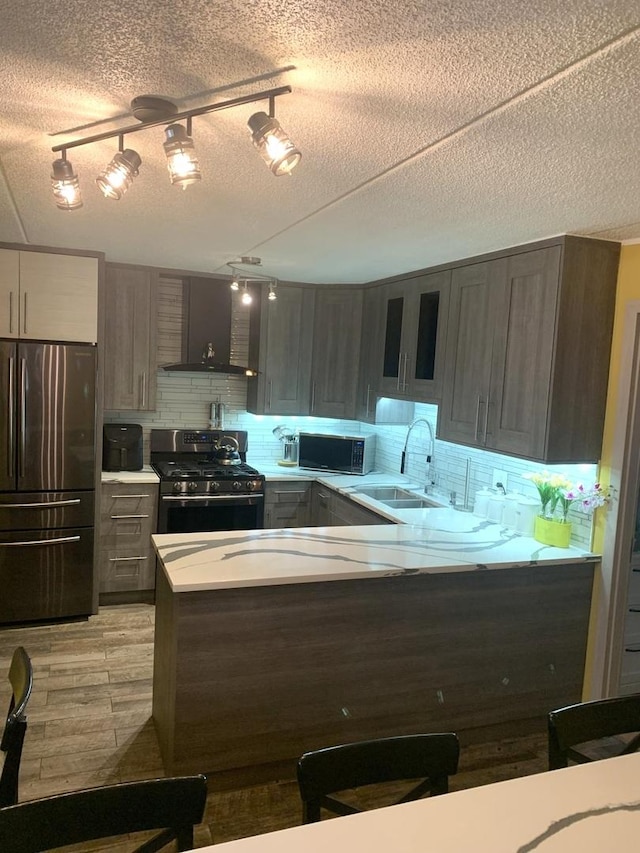 6430 W Belle Plaine Ave Unit 202, Chicago, IL 60634 - kitchen with stainless steel appliances, wall chimney exhaust hood, light countertops, decorative backsplash, and a textured ceiling