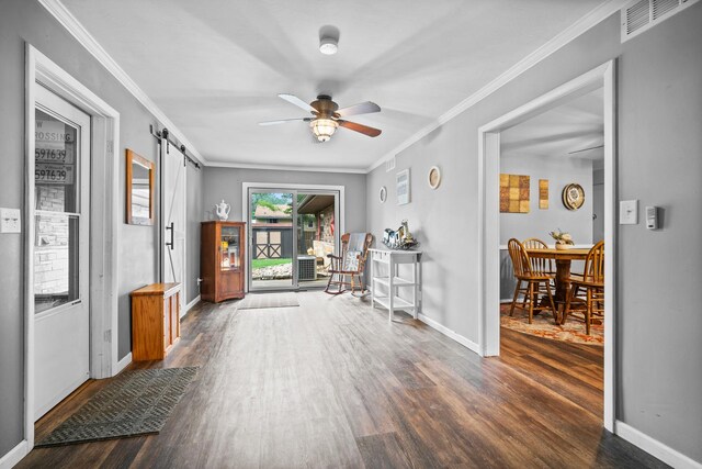 211 S E St, Hudson, IL 61748 - foyer entrance with a barn door, wood finished floors, a ceiling fan, crown molding, and baseboards