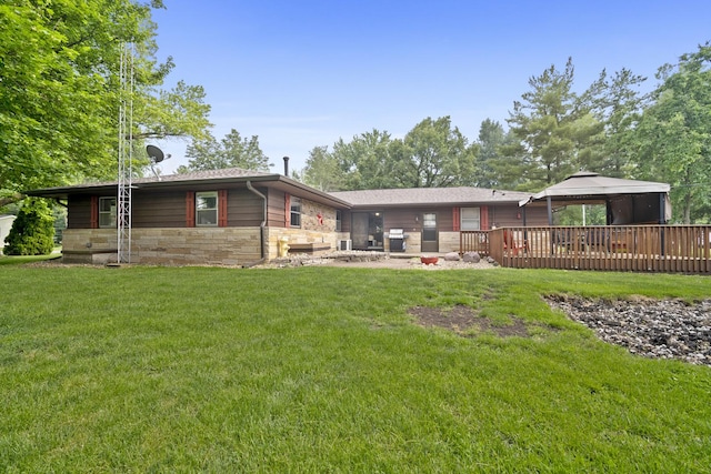 211 S E St, Hudson, IL 61748 - back of house with stone siding, a lawn, a gazebo, and a deck