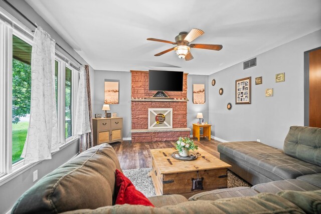 211 S E St, Hudson, IL 61748 - living area featuring ceiling fan, wood finished floors, baseboards, and a fireplace
