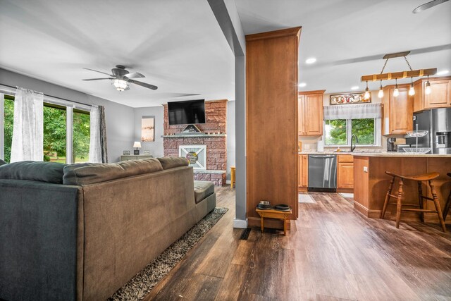 211 S E St, Hudson, IL 61748 - living area with healthy amount of natural light, ceiling fan, dark wood finished floors, recessed lighting, and a fireplace