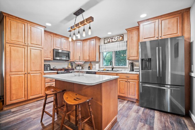 211 S E St, Hudson, IL 61748 - kitchen with appliances with stainless steel finishes, a sink, dark wood-type flooring, a center island, and recessed lighting