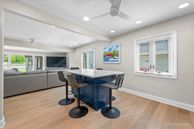 1599 Lowe Dr, Algonquin, IL 60102 - kitchen featuring ceiling fan, a kitchen breakfast bar, light wood-style floors, baseboards, and a center island