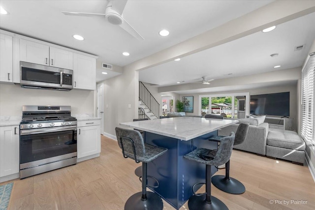 1599 Lowe Dr, Algonquin, IL 60102 - kitchen featuring stainless steel appliances, ceiling fan, open floor plan, white cabinetry, and a breakfast bar area