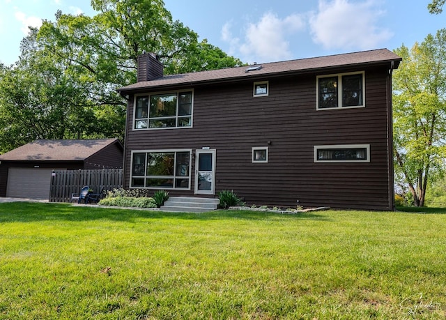 545 Delaware Dr, Lake In The Hills, IL 60156 - back of property featuring a chimney, a yard, and a detached garage