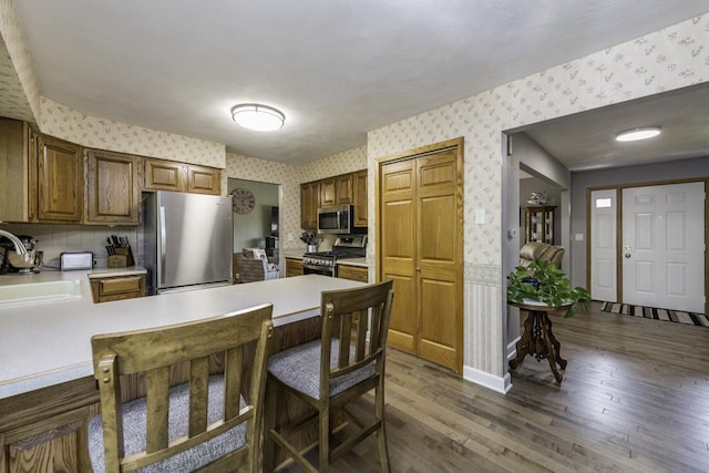 1401 Funderburk Dr, Winthrop Harbor, IL 60096 - kitchen with wallpapered walls, stainless steel appliances, a peninsula, a sink, and light countertops