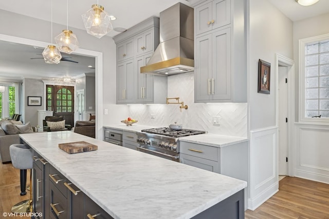 2319 W Shakespeare St, Chicago, IL 60647 - kitchen with wall chimney range hood, open floor plan, gray cabinetry, tasteful backsplash, and light wood finished floors