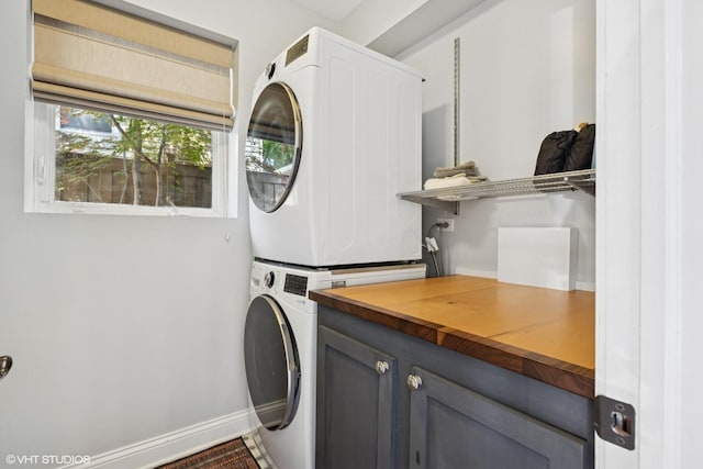 2319 W Shakespeare St, Chicago, IL 60647 - laundry area featuring stacked washer / drying machine, cabinet space, and baseboards