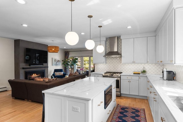 2530 W Morse Ave, Chicago, IL 60645 - kitchen featuring wall chimney exhaust hood, appliances with stainless steel finishes, open floor plan, light wood-type flooring, and tasteful backsplash
