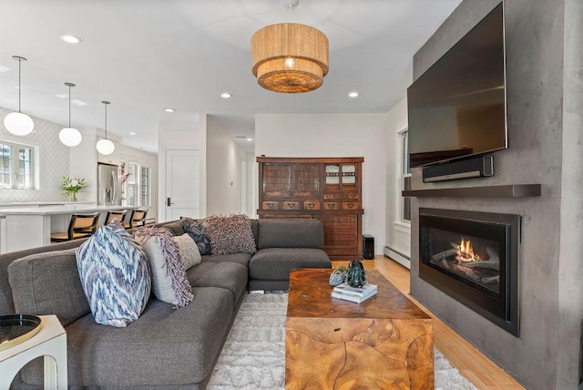 2530 W Morse Ave, Chicago, IL 60645 - living area with light wood-style flooring, a baseboard radiator, a glass covered fireplace, and recessed lighting