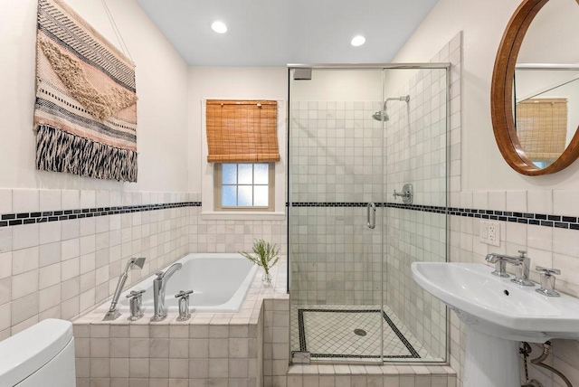 2530 W Morse Ave, Chicago, IL 60645 - bathroom with tile walls, a garden tub, a shower stall, recessed lighting, and a wainscoted wall