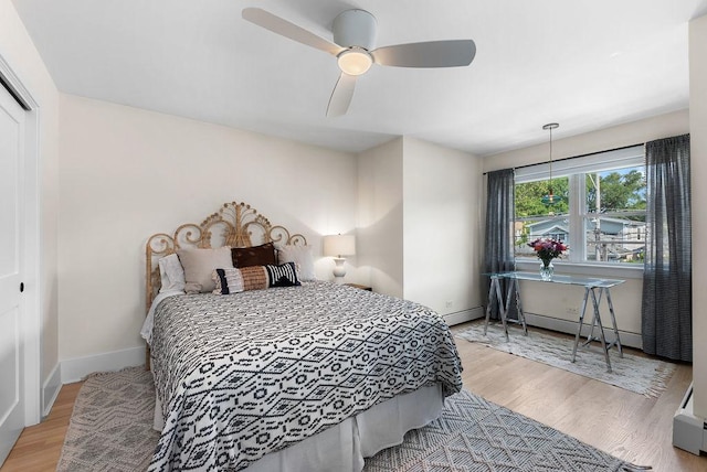 2530 W Morse Ave, Chicago, IL 60645 - bedroom featuring wood finished floors, baseboard heating, ceiling fan, and a closet