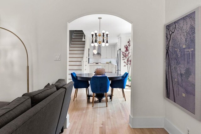 2530 W Morse Ave, Chicago, IL 60645 - dining space featuring stairway, arched walkways, light wood finished floors, and a chandelier