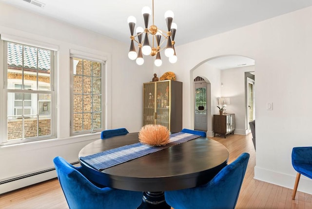 2530 W Morse Ave, Chicago, IL 60645 - dining room with arched walkways, wood finished floors, a chandelier, and a baseboard radiator