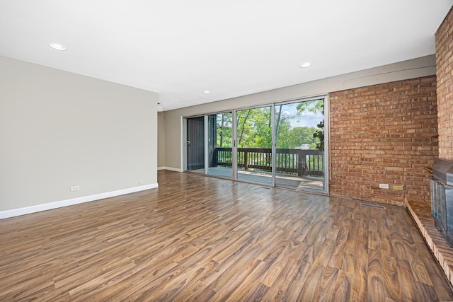5515 Lakeside Dr Unit 1D, Lisle, IL 60532 - unfurnished living room featuring wood finished floors, baseboards, recessed lighting, and brick wall