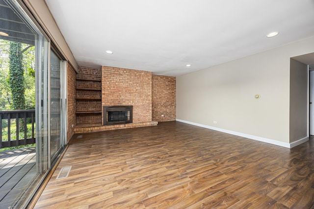 5515 Lakeside Dr Unit 1D, Lisle, IL 60532 - unfurnished living room with wood finished floors, brick wall, baseboards, a fireplace, and recessed lighting