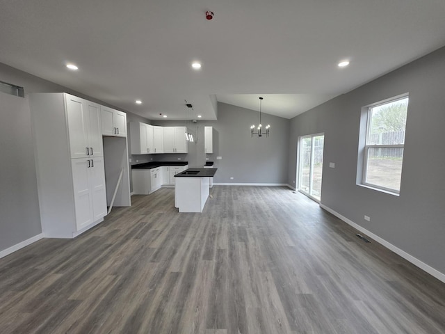 1390 Merrimac Ln, Hanover Park, IL 60133 - kitchen with open floor plan, a chandelier, baseboards, dark countertops, and lofted ceiling
