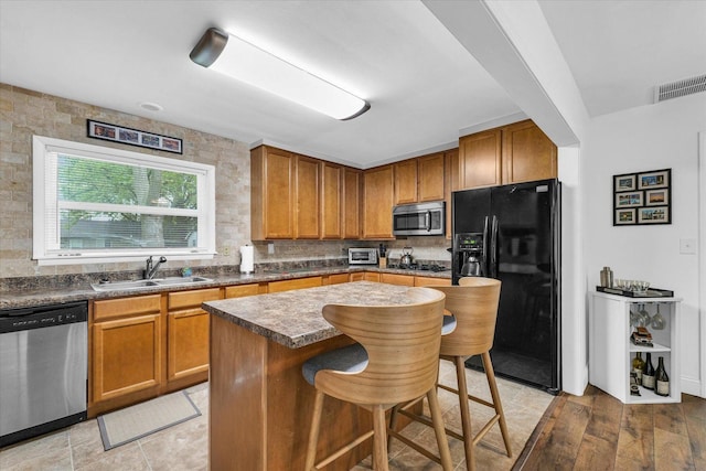 1905 Easy St, Urbana, IL 61802 - kitchen featuring black appliances, brown cabinetry, a kitchen breakfast bar, and dark countertops