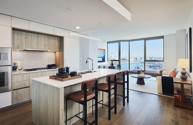 211 N Harbor Dr Unit 1404, Chicago, IL 60601 - kitchen featuring modern cabinets, a kitchen bar, light countertops, tasteful backsplash, and white gas stovetop