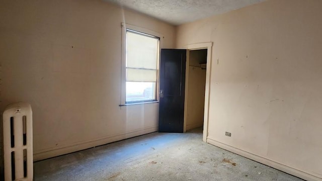 5330 W Foster Ave, Chicago, IL 60630 - unfurnished bedroom featuring radiator heating unit and a textured ceiling