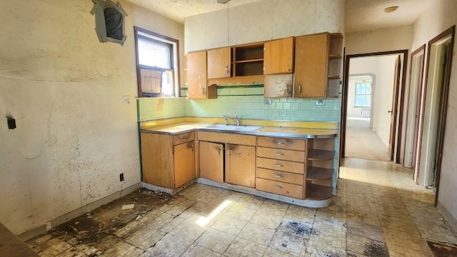 5330 W Foster Ave, Chicago, IL 60630 - kitchen featuring open shelves, light countertops, backsplash, and brown cabinetry