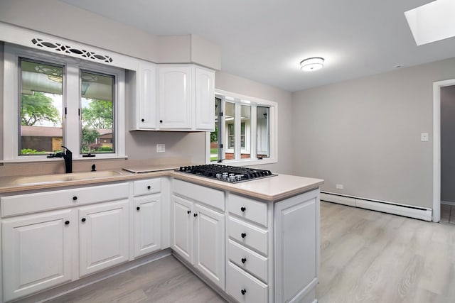6231 W 127th Pl, Palos Heights, IL 60463 - kitchen featuring stainless steel gas cooktop, a baseboard radiator, a skylight, light wood-style floors, and a peninsula