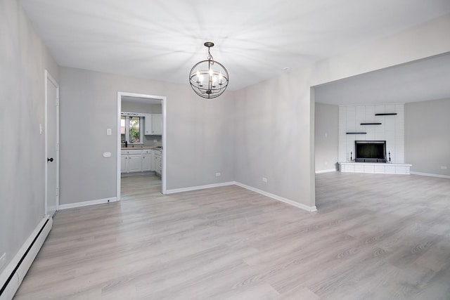 6231 W 127th Pl, Palos Heights, IL 60463 - unfurnished living room featuring a baseboard heating unit, a chandelier, light wood-style flooring, and a brick fireplace